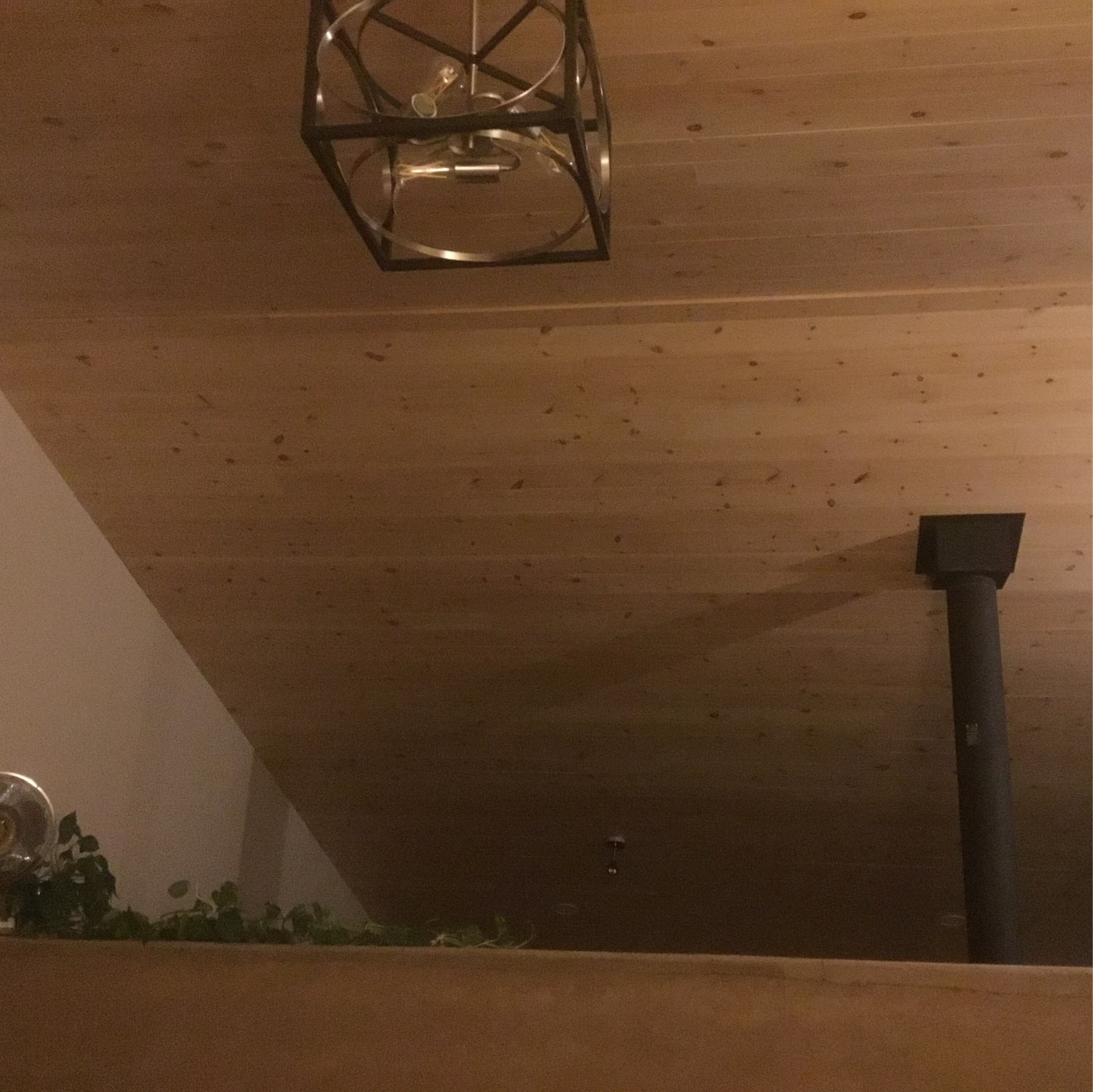 pine ceiling, square light fixture and rammed earth half-wall