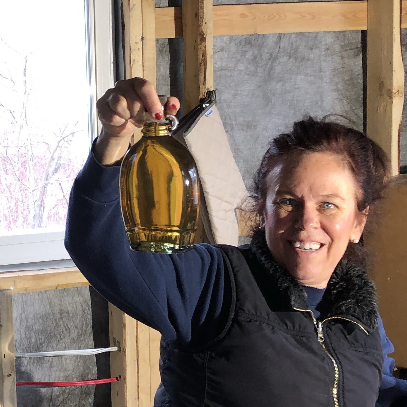 lady holding up a bottle of maple syrup