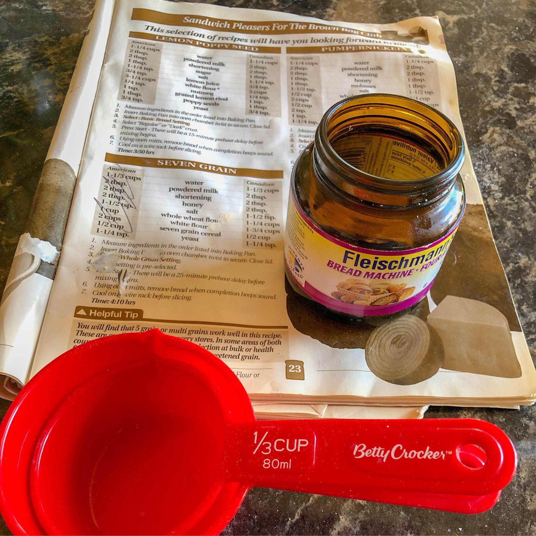 measuring cups, empty yeast jar and bread recipe book