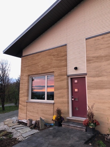 sunrise in a house window. the house is a golden colour with cream trim. 