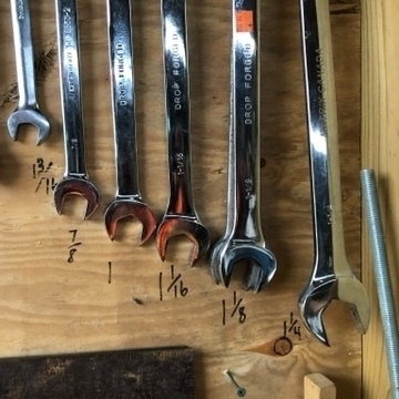 series of wrenches hanging on plywood. Labels say, 13/16", 7/8", 1", 1 1/16"