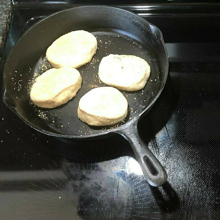 English muffins cooking in an ungreased frying pan