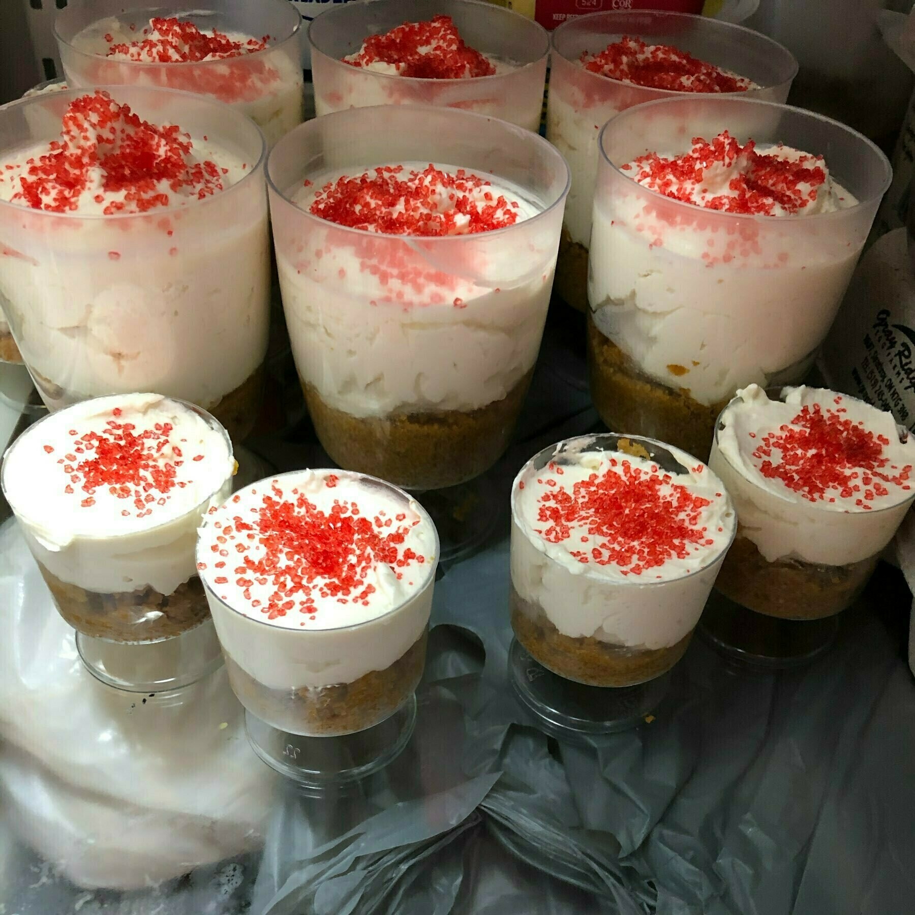 several small containers of white cheesecake with red sprinkles on top