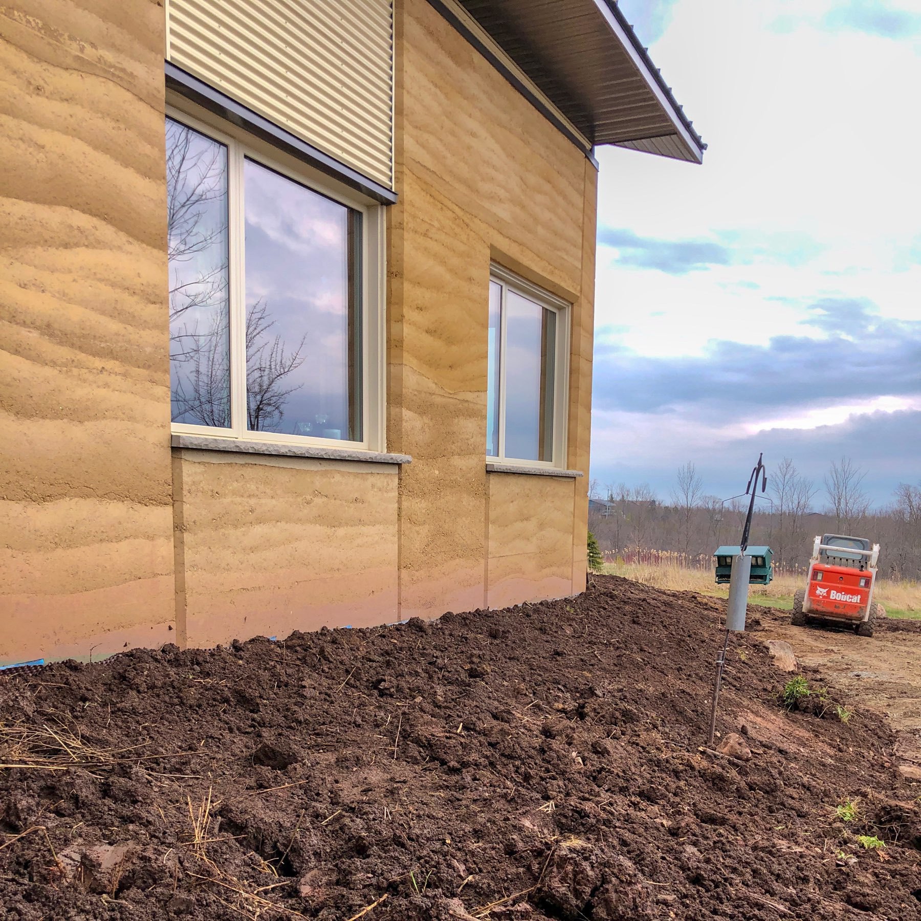 new topsoil placed along the house. bobcat in the distance