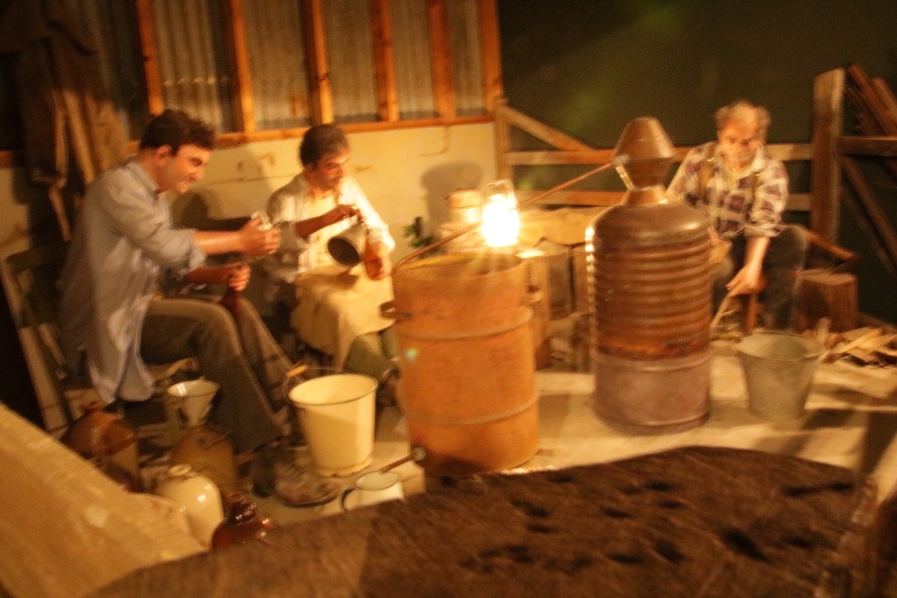 men sitting around a barrel with a long snout