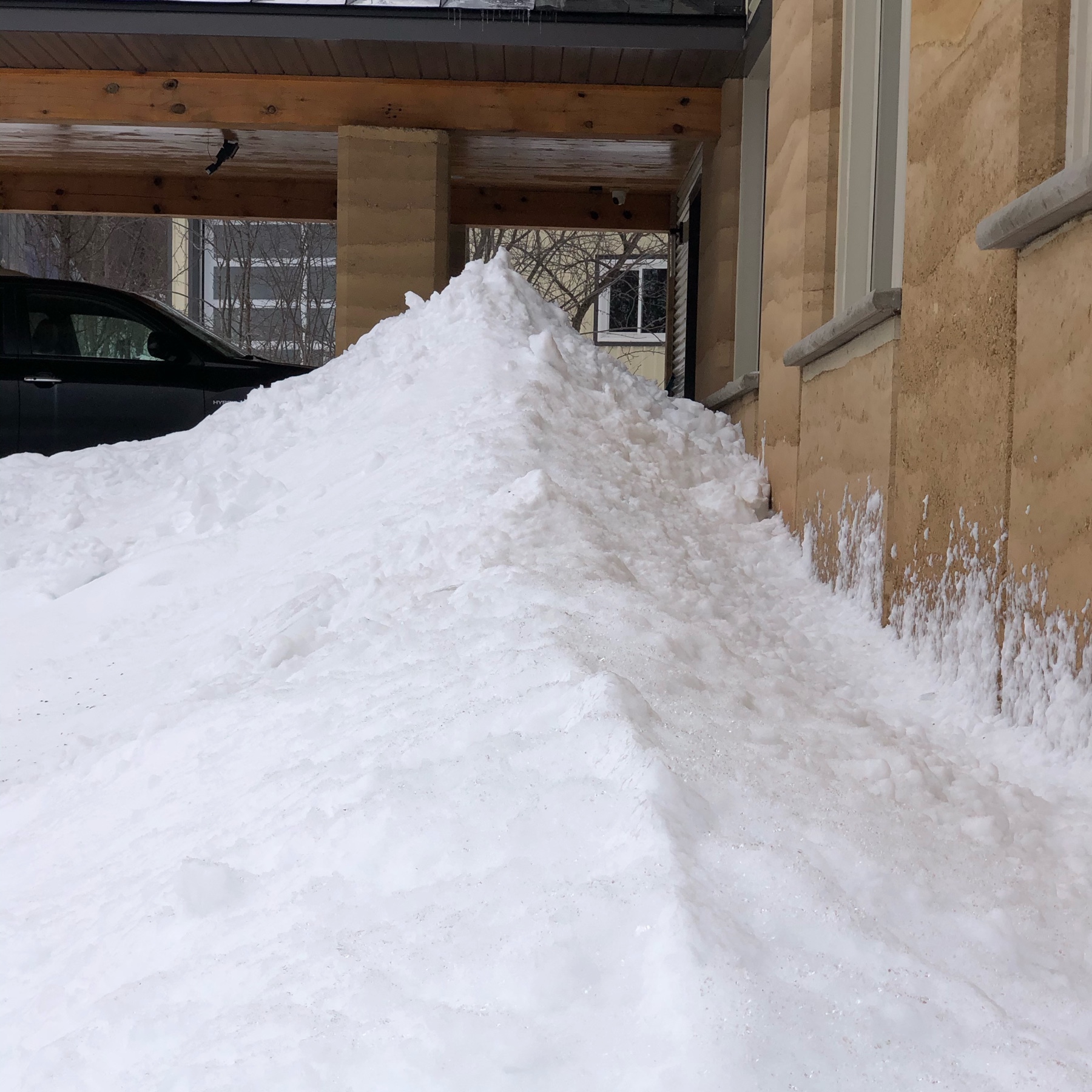 tall, pointed pile of snow next to a house