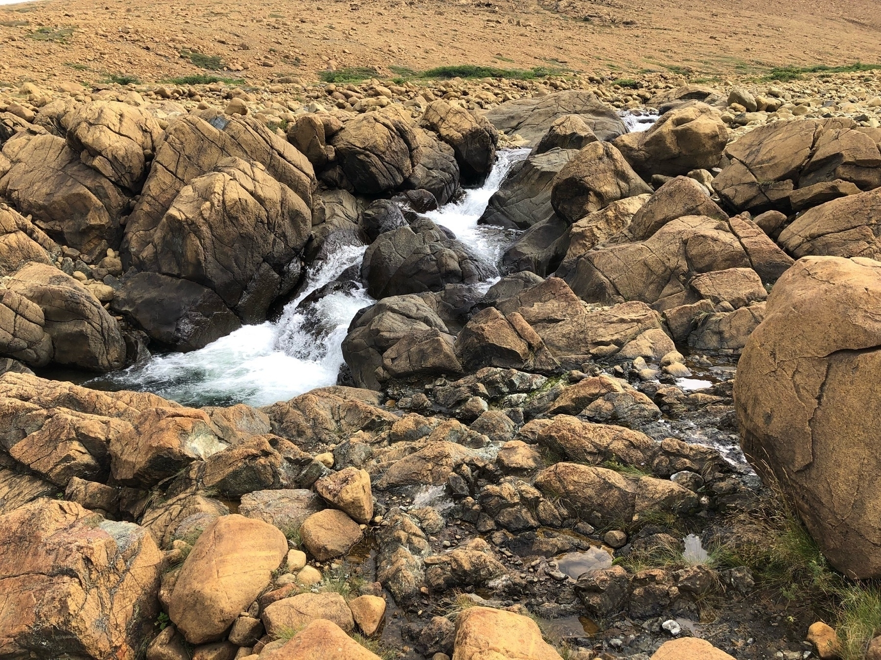 water flowing amongst rust-coloured rocks