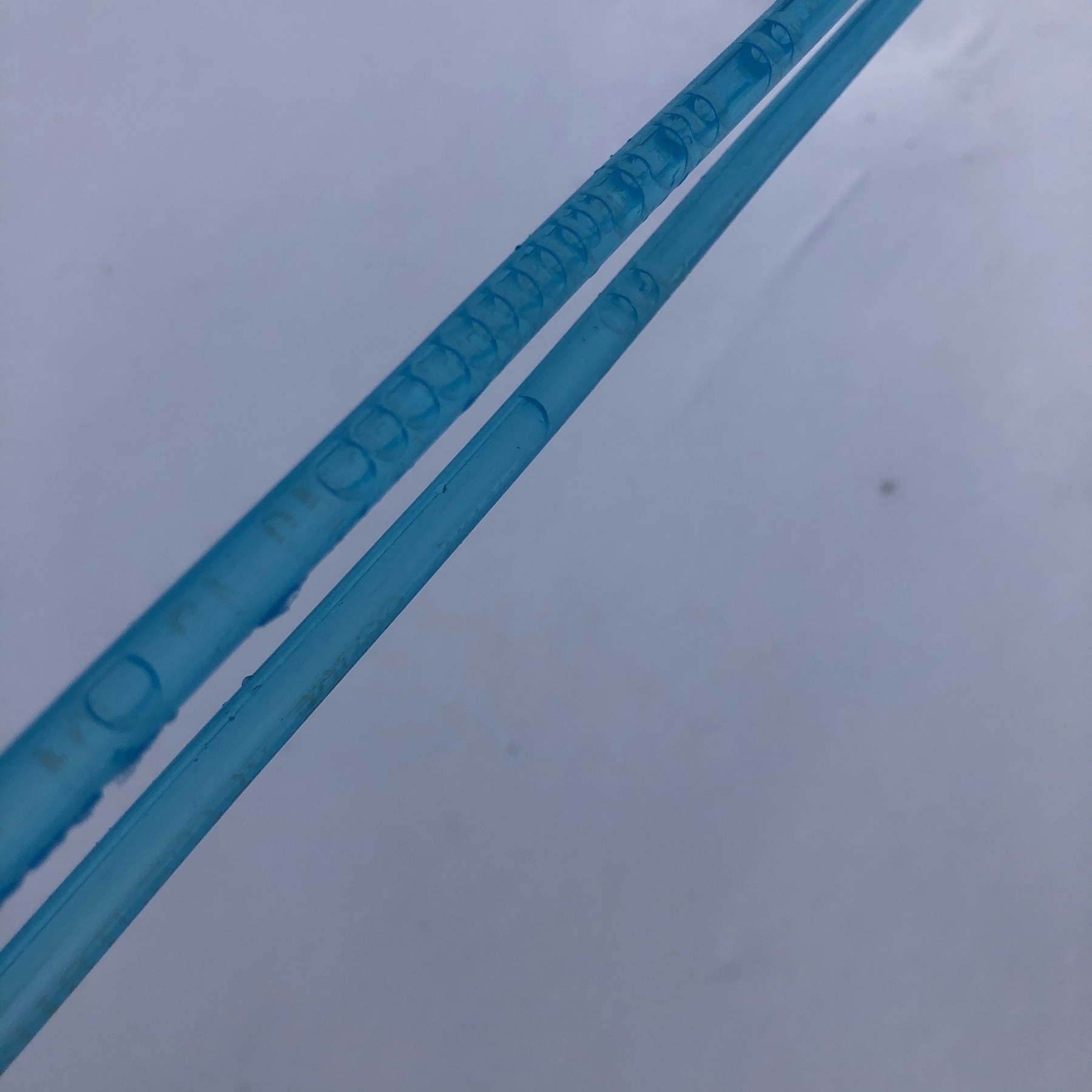 two lines of blue tubing full of bubbles, suspemded over snow