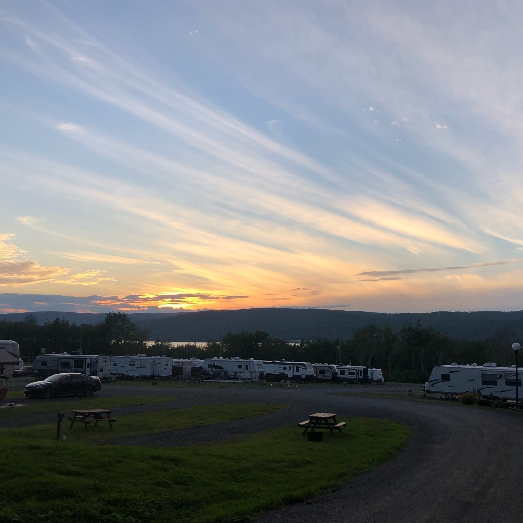 sunset over a campground. there is a large hill in the background