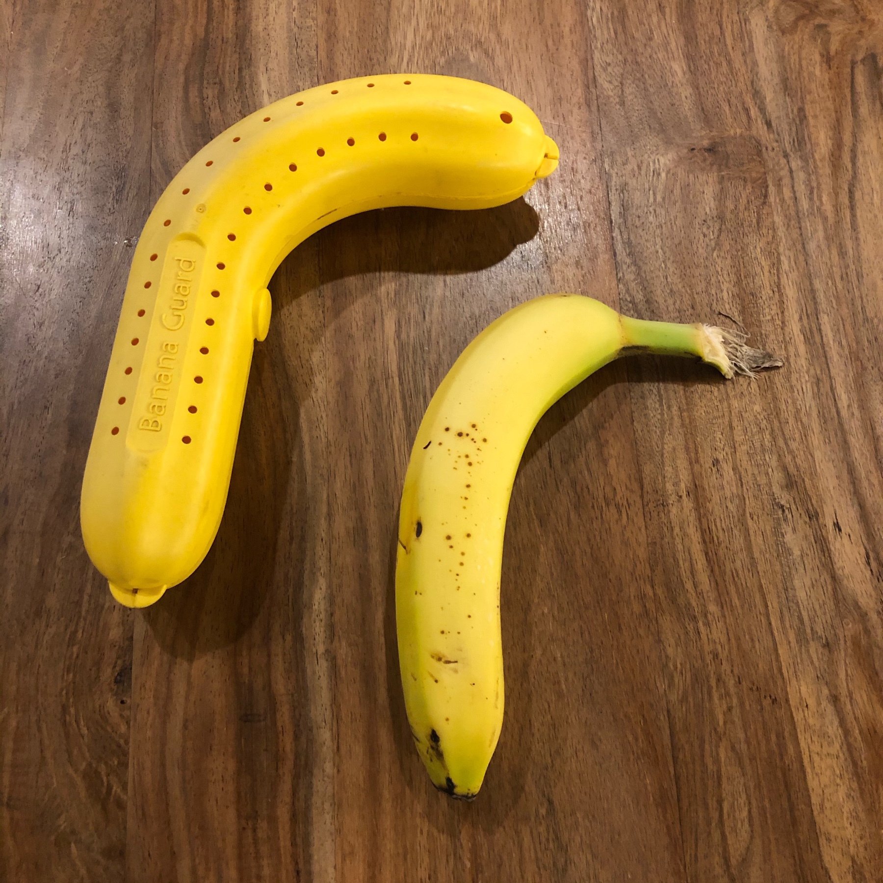a yellow, plastic, banana-shaped container and a banana