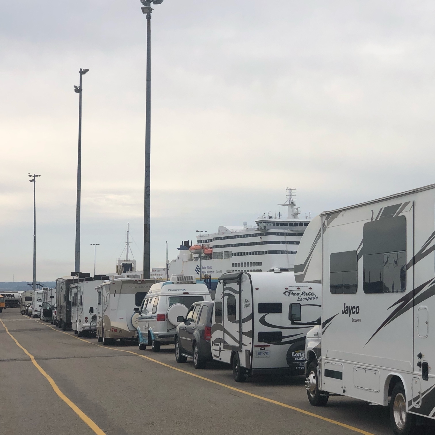 row of recreation vehicles. there is a ferry in the background