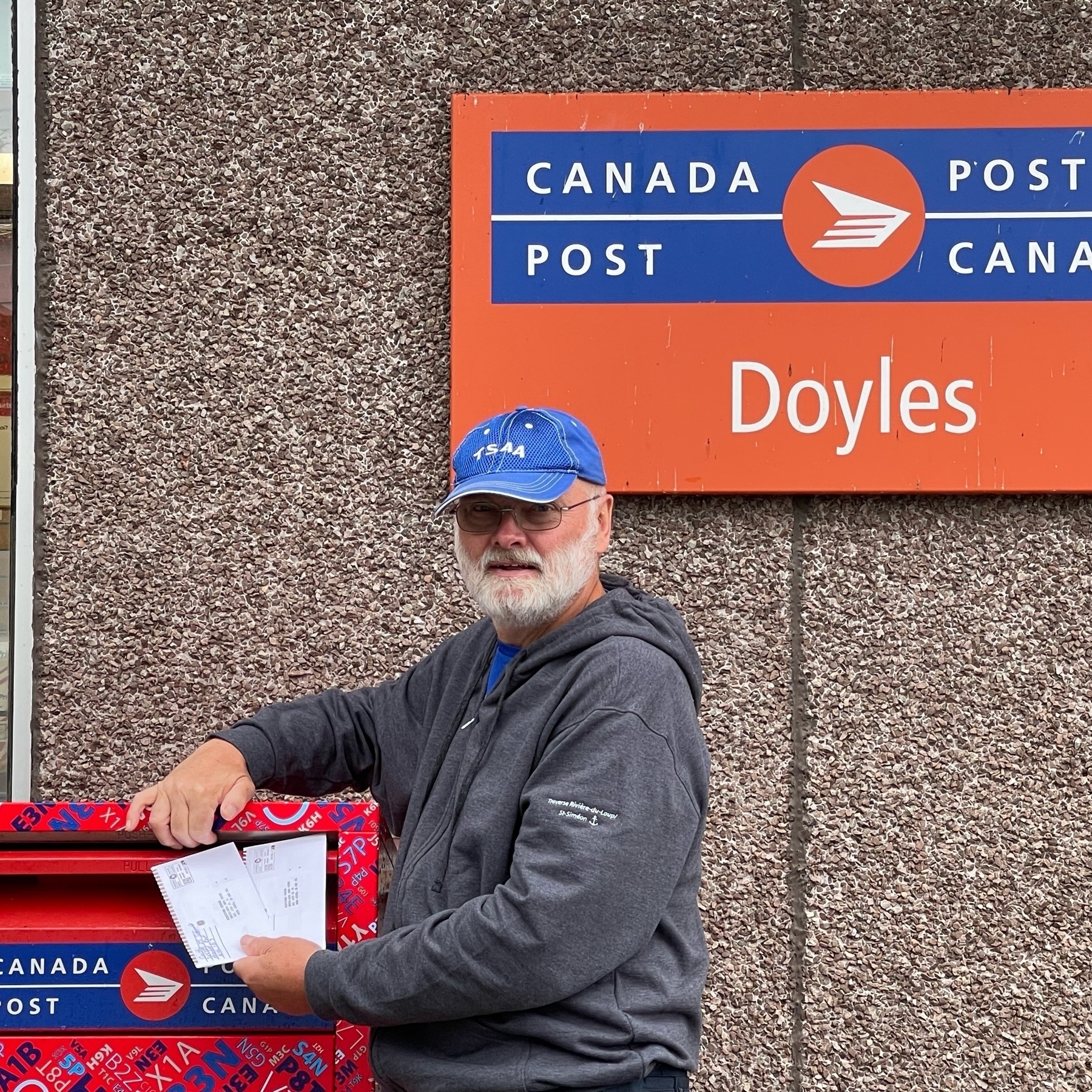man mailing two envelops at Doyles post office