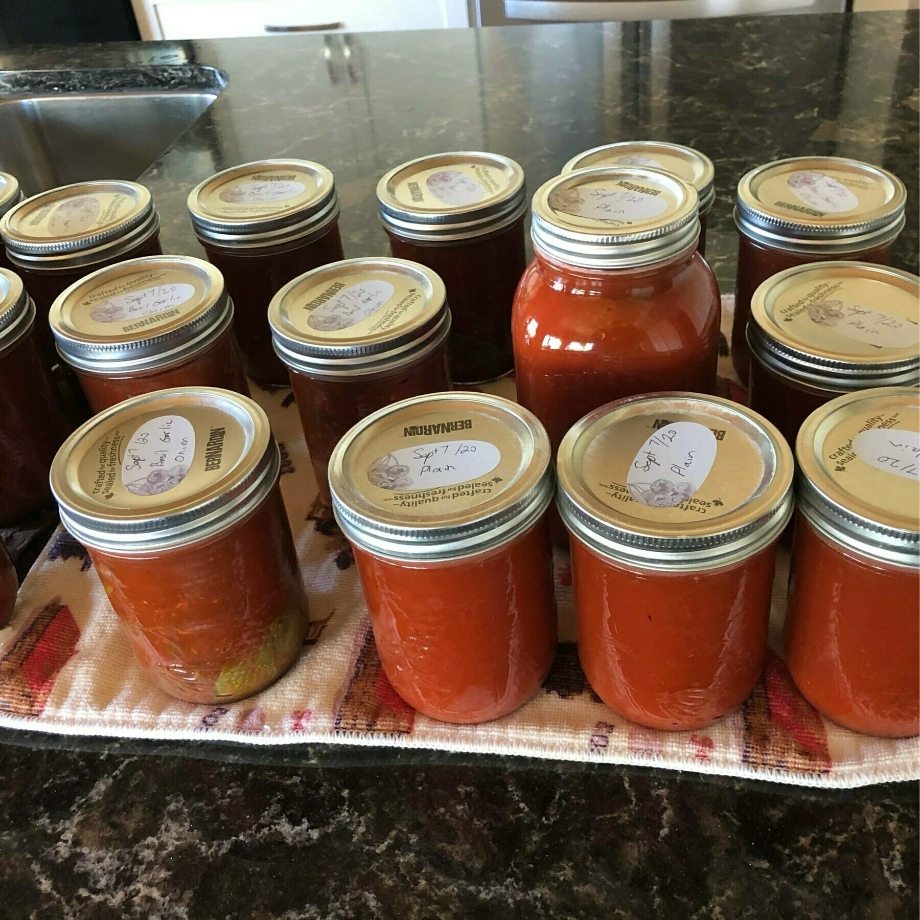 multiple jars of tomato sauce sitting on a dark countertop