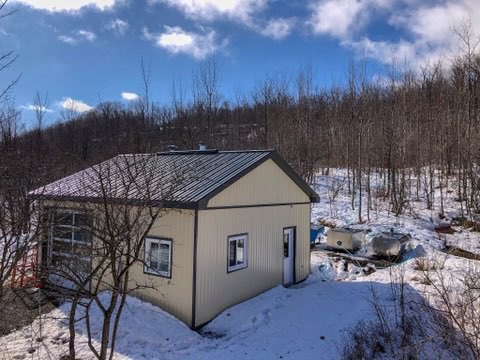 sugar house showing sap tanks and bush behind