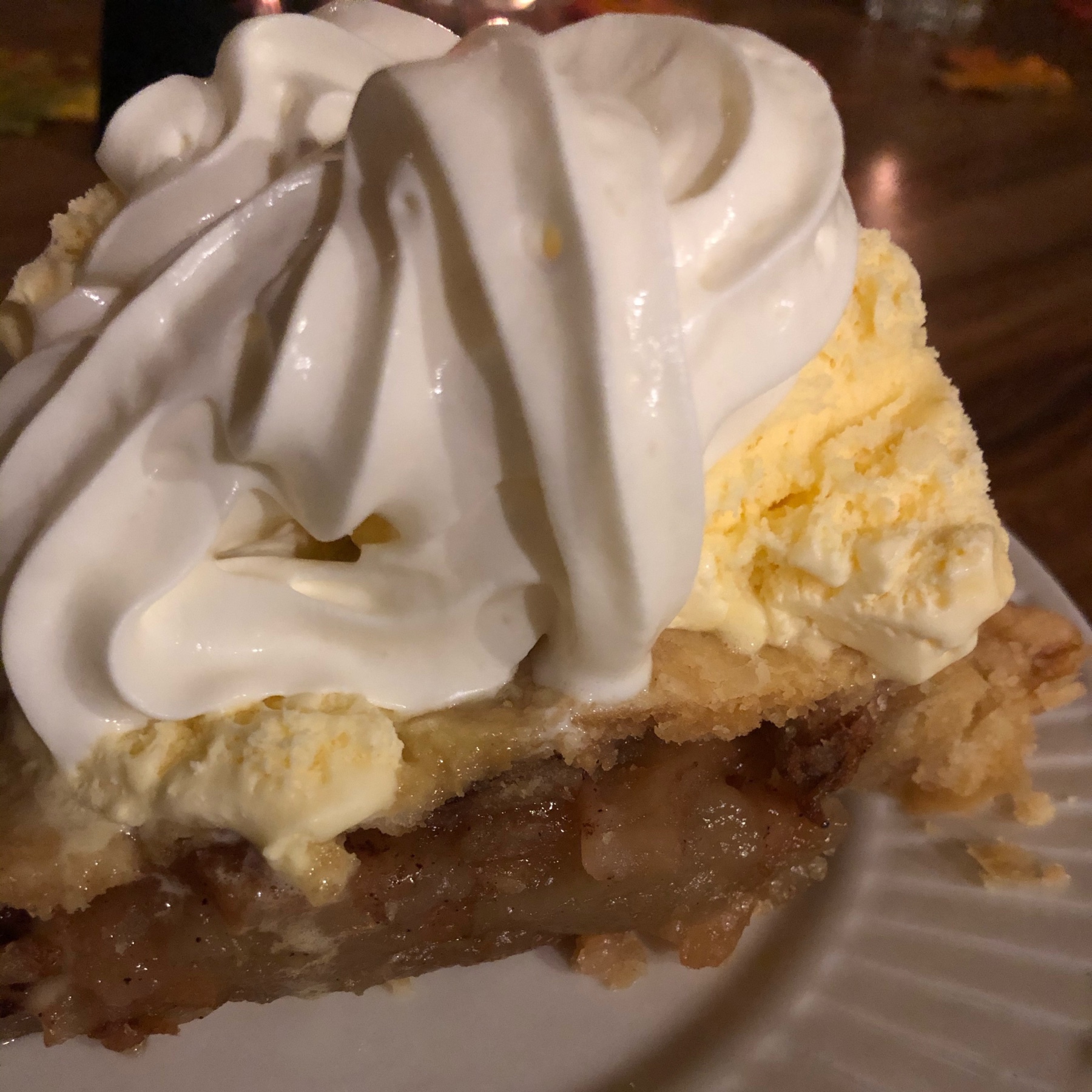 a slice of apple pie with whopped cream on top