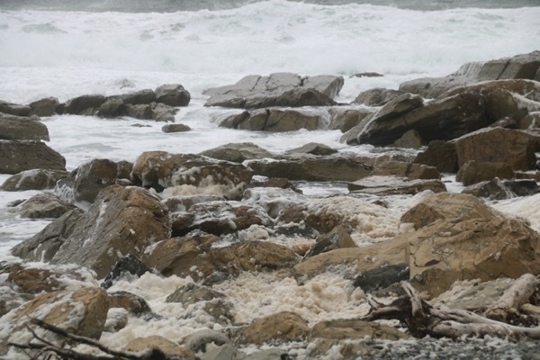 foam on water mixing around rocks