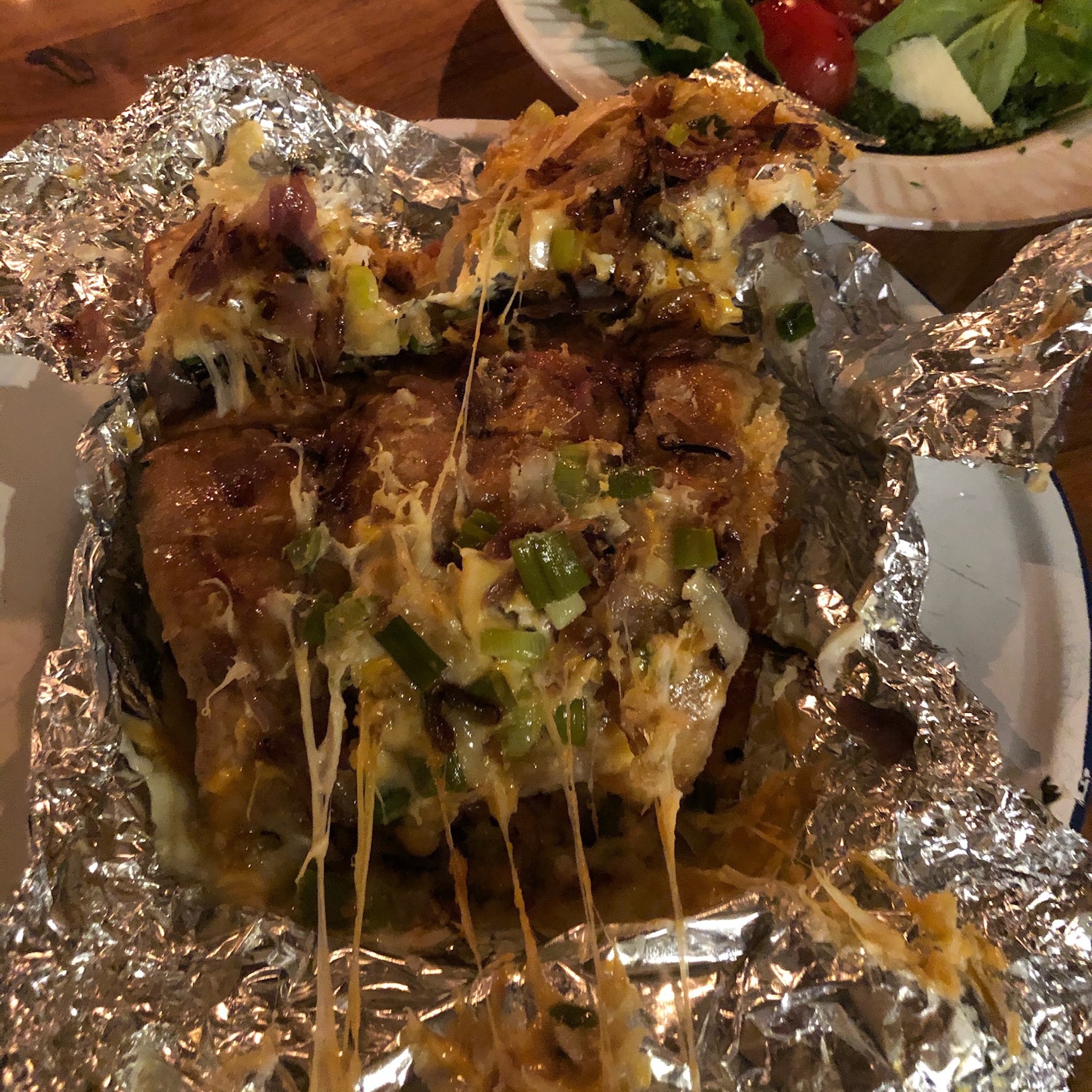 Runny cheese and onion mixture on bread surrounded by foil wrap