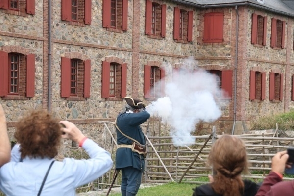 smoke from the barrel of a musket. tourists in front taking photos