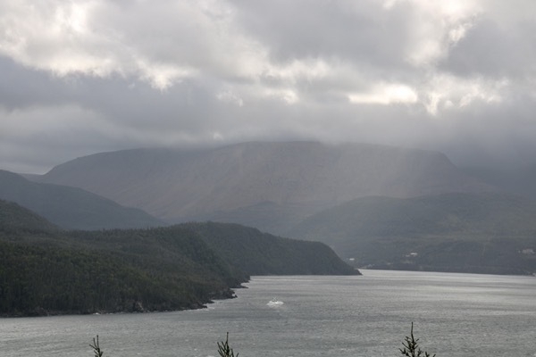 small tour boat surrounded by mountains